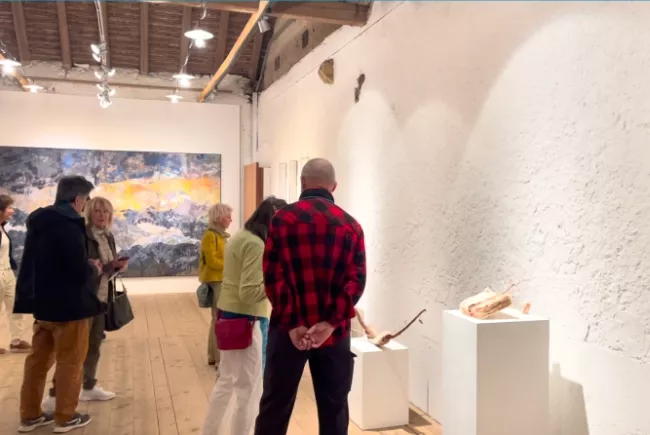 Visiteurs admirant et discutant des oeuvres exposées au sein de la galerie du premier étage